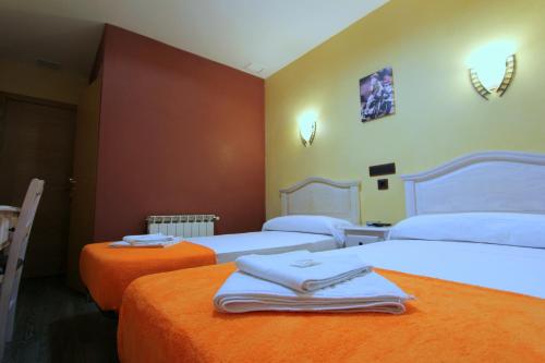 a room with three beds with towels on them at Hostal Regio in Madrid