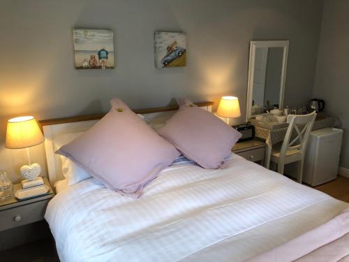 a bedroom with a bed with white sheets and pillows at "The Lodge", Holmfirth in Holmfirth