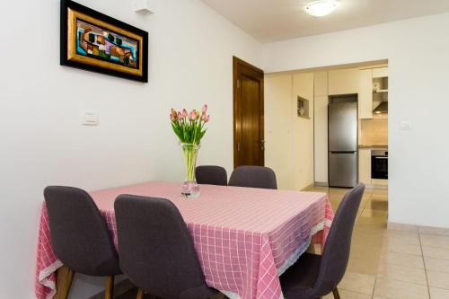 a dining room table with a vase of flowers on it at Apartments Leon in Podstrana