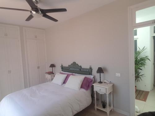 - une chambre avec un lit blanc et des oreillers violets dans l'établissement La Solandra, à Adeje