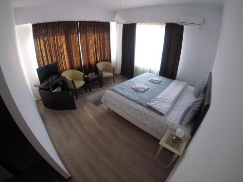 een slaapkamer met een bed en een bureau met een computer bij Cochet Accommodation in Piatra Neamţ