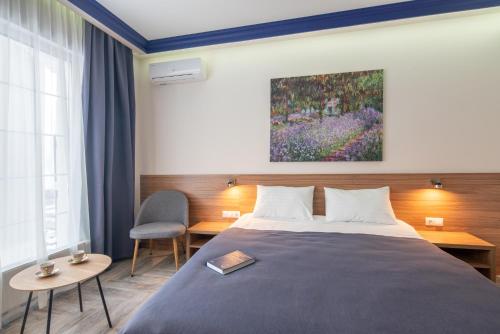 a bedroom with a bed and a painting on the wall at Comfort House in Kyiv