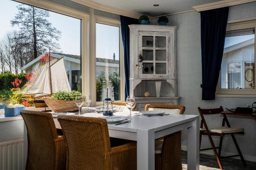 a dining room with a white table and chairs at Chaletparc Krabbenkreek Zeeland - Chalet 50 in Sint Annaland