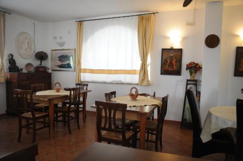 a dining room with tables and chairs and a window at Villa Grazia in Capo Vaticano