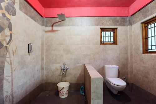 a bathroom with a toilet and a shower at Rustling River Resort in Ooty