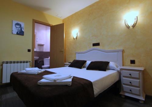 a bedroom with a large bed with towels on it at Hostal Regio in Madrid