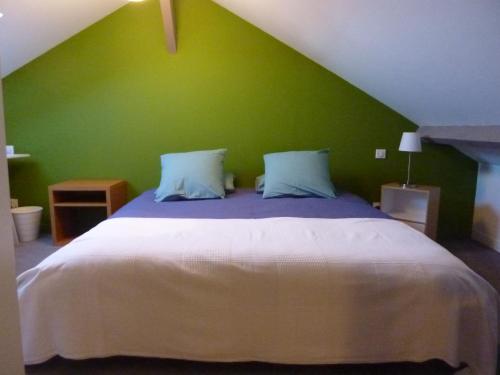 1 dormitorio con 1 cama grande y pared verde en Etage privatif en Tarbes