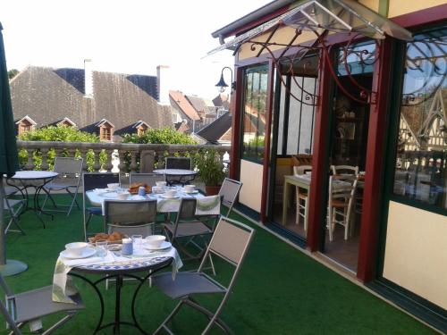 a patio with tables and chairs and a building at Logis Hotel La Tourelle du Beffroi in Bourbon-Lancy