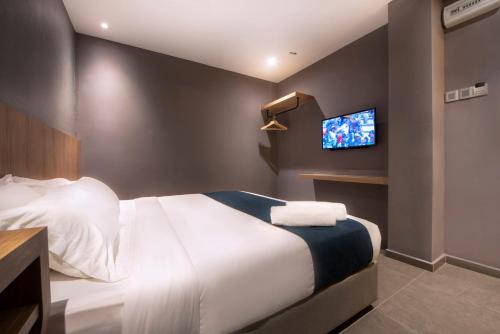 a hotel room with a bed and a tv at Orange Business Hotel Petaling Jaya in Petaling Jaya