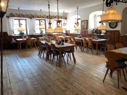 uma sala de jantar com mesas e cadeiras de madeira em Hotel zur Post em Kreuth