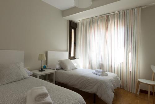 a hotel room with two beds and a window at APARTAMENTOS OASIS in Zamora