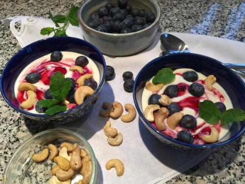 two bowls of fruit salad with nuts and blueberries at Bed & Breakfast Kortenhoefsedijk in Kortenhoef