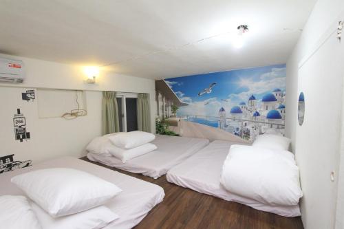 two beds in a room with a mural on the wall at Sea Keelung in Keelung