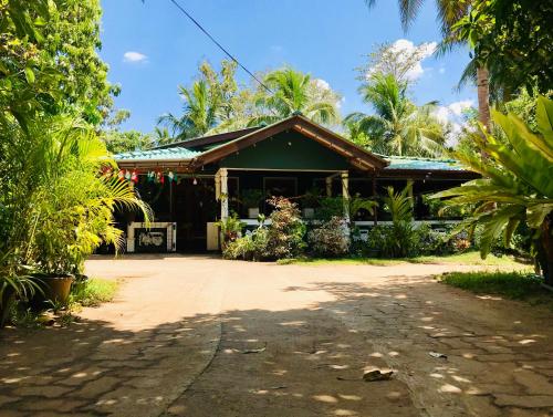 a house in the middle of a yard with trees at Sigiri Saman Home Stay in Sigiriya