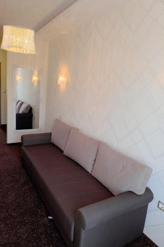 a couch in a living room with a mirror at Vácz Hotel in Vác