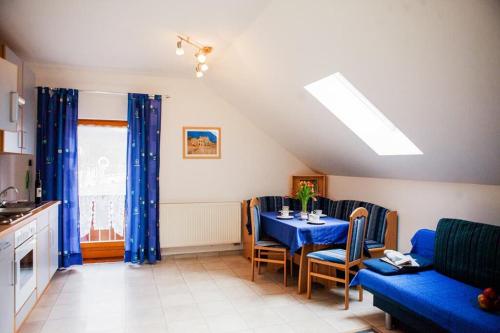 a living room with a table and blue curtains at Sixt Martina in Lam
