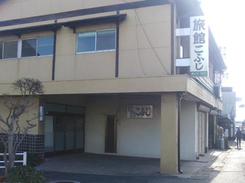 a building with a sign on the side of it at Kofuji Ryokan in Kurashiki