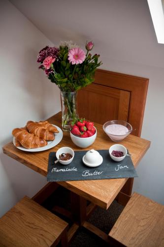 a table with a vase of flowers and a plate of food at Lugonia in Pitlochry