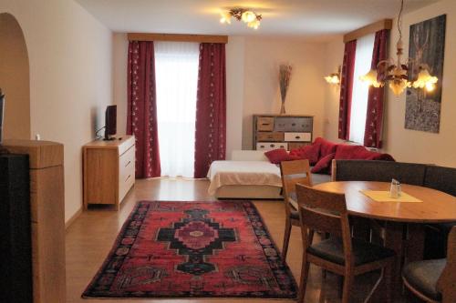 a living room with a bed and a dining room at Sieglhub Chalets - Appartements - Hotel in Flachau