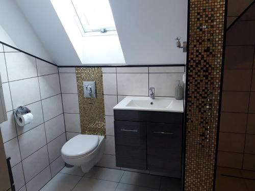 a bathroom with a toilet and a sink at Apartamenty Krótka 3 in Świeradów-Zdrój