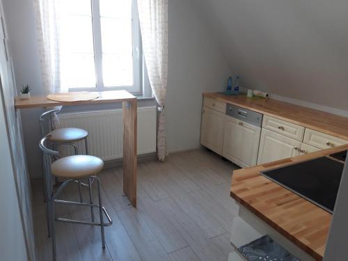 a kitchen with a counter and a stool and a table at Apartamenty Krótka 3 in Świeradów-Zdrój