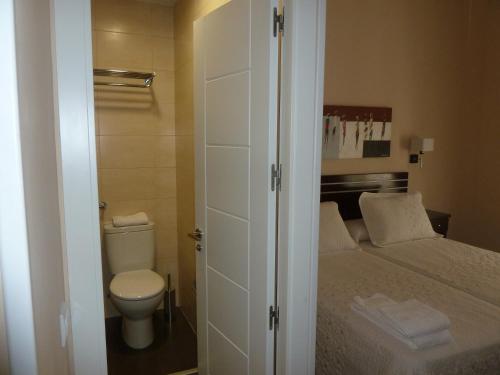 a small bathroom with a bed and a toilet at Hostal Mayor in Madrid