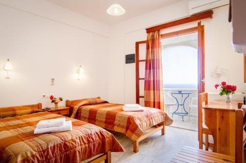 イオス島 チョーラにあるVillage Twinsのベッド2台と窓が備わるホテルルームです。