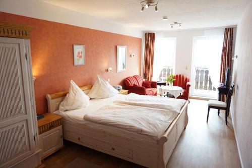 um quarto com uma cama e uma sala de estar em Pension Tüxen em Hasselberg