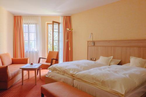 ein Schlafzimmer mit einem Bett, einem Stuhl und einem Tisch in der Unterkunft Hotel St.Martiner Castell in Sankt Martin