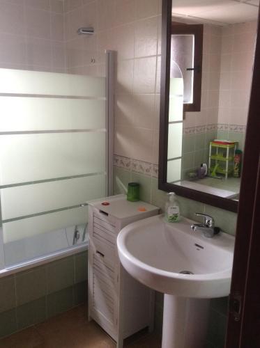 a bathroom with a sink and a mirror and a tub at Costa Esuri Ayamonte Apartment in Ayamonte