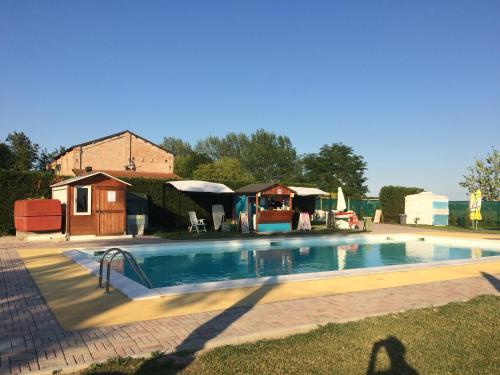 a large swimming pool in a yard with a house at Agriturismo Trava in Portoverrara