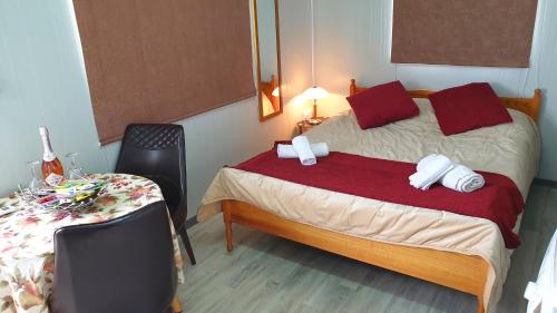 a bedroom with a bed with red pillows and a table at Astrofegia Apartments Near The Sea in Ayia Marina