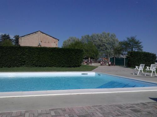 a swimming pool in a yard with a building at Agriturismo Trava in Portoverrara