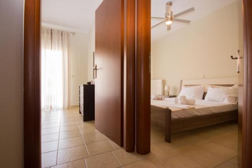 - une chambre avec un lit et un grand miroir dans l'établissement Keramoti Luxury Apartments, à Keramoti