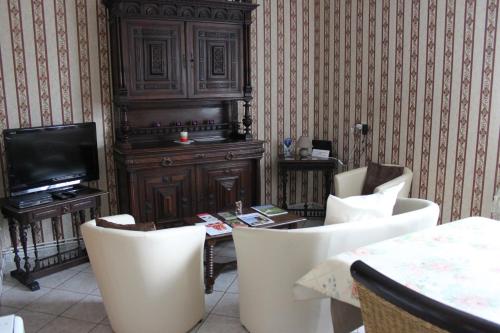 une pièce avec une table, des chaises et une télévision dans l'établissement Maison de Gaby 2 étoiles tourisme 2 ou 4 Personnes, à Vitrac