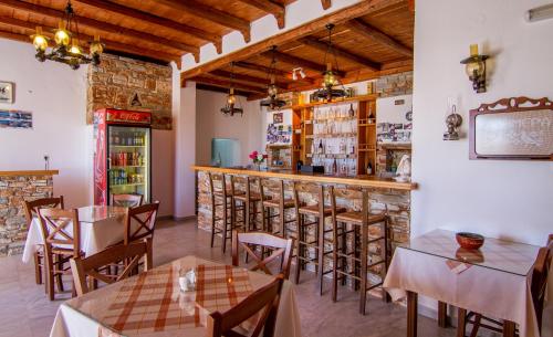 a restaurant with tables and chairs and a bar at Village Twins in Ios Chora
