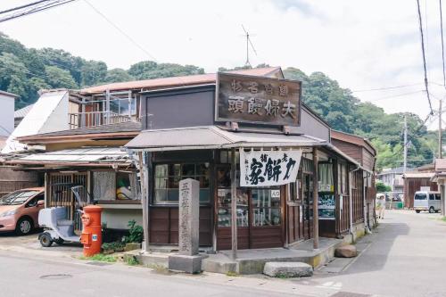 a building with a sign on the side of a street at Villa Kamakura in Kamakura