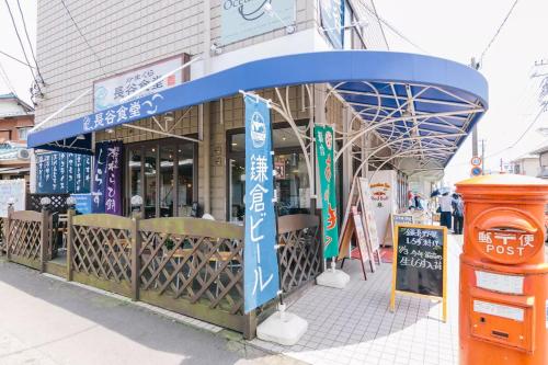 a building with a blue canopy in front of it at Villa Kamakura in Kamakura