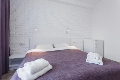 a bedroom with a bed with towels on it at SkyHome na Nauky in Kyiv