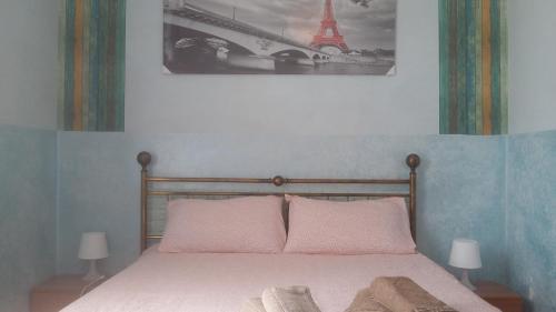 a bedroom with a bed and a picture of the eiffel tower at Grande Appartamento Dei Mille in Novi Ligure