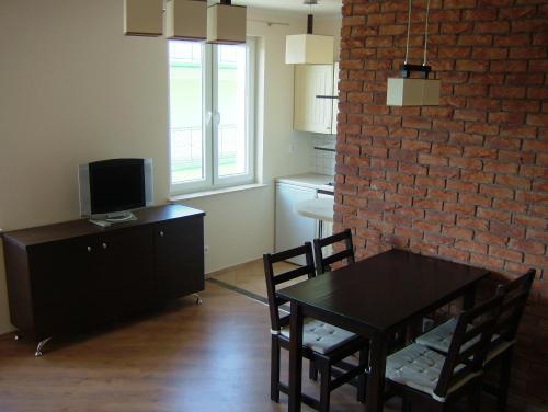 a dining room with a table and a brick wall at Los Reyes in Krynica Morska