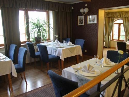 a dining room with two tables and blue chairs at Tähetorni Hotel in Tallinn