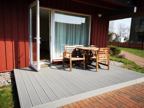 a wooden deck with a table and chairs on a house at Atostogos Pervalkoje in Pervalka