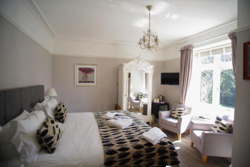 a bedroom with a large bed and a living room at Dene House Guest House in Bowness-on-Windermere