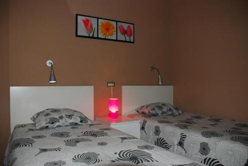 a bedroom with two beds and a pink candle at Apartamentos las Dunas in Playa del Ingles