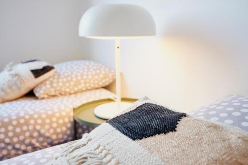 a bedroom with a bed with a table and a lamp at Jean Bart - proximité centre - 2 chambres 90 m2 avec jardin in Saint-Brieuc