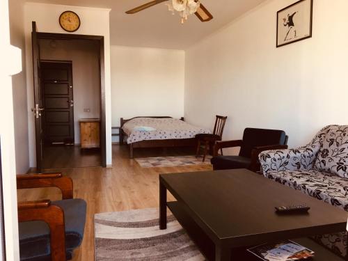 ein Wohnzimmer mit einem Sofa und einem Tisch in der Unterkunft Clean apartment on Lunacharskogo street in Tiraspol