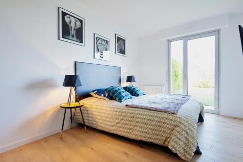 um quarto com uma cama, 2 candeeiros e uma janela em Jean Bart - proximité centre - 2 chambres 90 m2 avec jardin em Saint-Brieuc