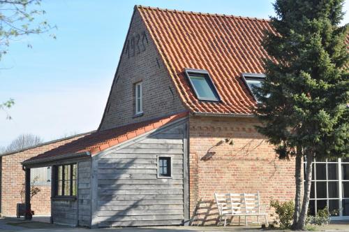 a small brick building with a gambrel roof at Wilgenwind in Sijsele