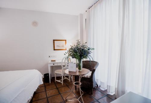 a bedroom with a table with a vase of flowers on it at Palacio De Los Navas in Granada